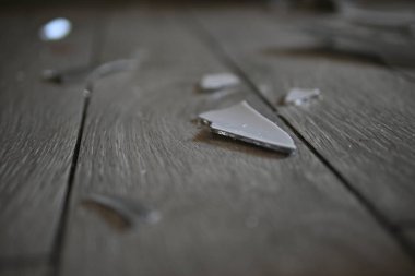 Cam kırıkları zemin üzerinde, kırık tabaklar arka plan gibi gri.