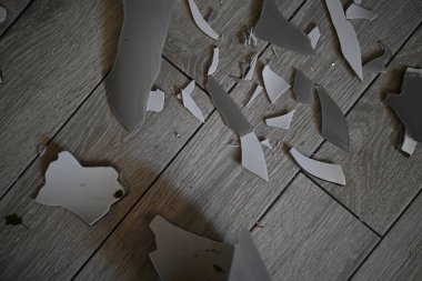 Cam kırıkları zemin üzerinde, kırık tabaklar arka plan gibi gri.