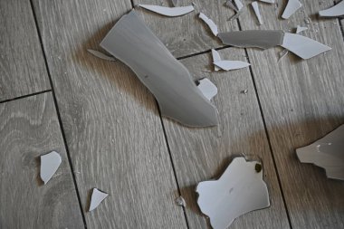 Cam kırıkları zemin üzerinde, kırık tabaklar arka plan gibi gri.