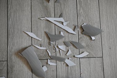 Cam kırıkları zemin üzerinde, kırık tabaklar arka plan gibi gri.