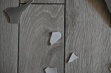 Cam kırıkları zemin üzerinde, kırık tabaklar arka plan gibi gri.