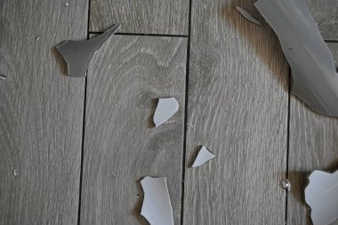 Gri zemindeki vazo parçaları, bir turşu sonrası, yerde kırılan vazo parçaları.