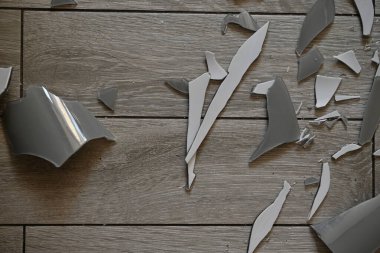 Gri zemindeki vazo parçaları, bir turşu sonrası, yerde kırılan vazo parçaları.