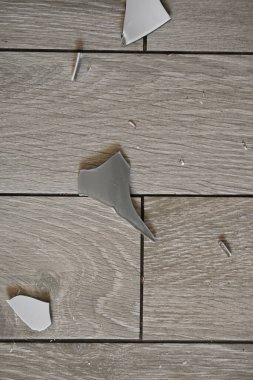 Gri zemindeki vazo parçaları, bir turşu sonrası, yerde kırılan vazo parçaları.