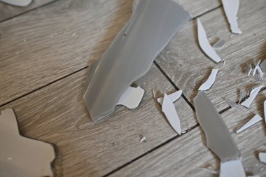 Gri zemindeki vazo parçaları, bir turşu sonrası, yerde kırılan vazo parçaları.