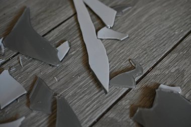 Gri zemindeki vazo parçaları, bir turşu sonrası, yerde kırılan vazo parçaları.