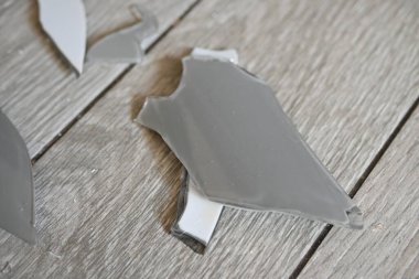 Gri zemindeki vazo parçaları, bir turşu sonrası, yerde kırılan vazo parçaları.