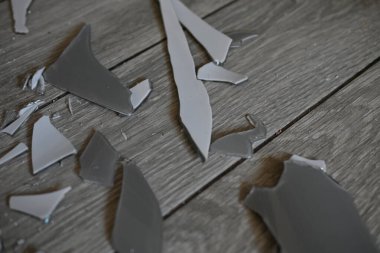 Cam kırıkları zemin üzerinde, kırık tabaklar arka plan gibi gri.