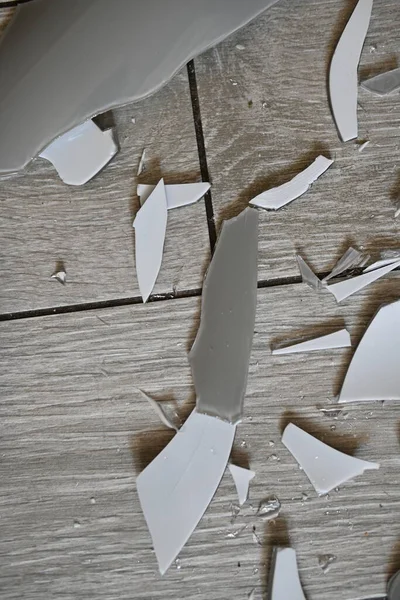 Gri zemindeki vazo parçaları, bir turşu sonrası, yerde kırılan vazo parçaları.