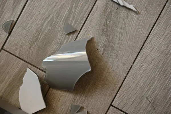 Gri zemindeki vazo parçaları, bir turşu sonrası, yerde kırılan vazo parçaları.