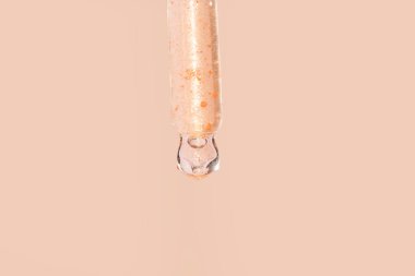 Güzellik projeniz için bej arka planda parlak bir yüz serumu serumu ile pipet damlatıcısını kapatın.