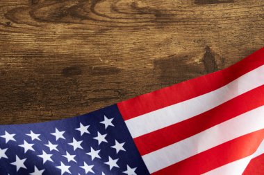 Siyah ahşap bir masanın altındaki Amerikan bayrağının üst görüntüsü fotokopi alanı ile ulusal etkinlikler için uygundur. Başkanlar Günü, İşçi Bayramı, Anma Günü, Bağımsızlık Günü, Gaziler Günü gibi.