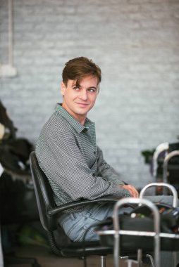 Yakışıklı beyaz adam kuaförde oturuyor. Saçını kestirip, kuaförlük yapıyor..