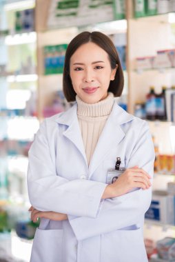 Eczanede duran kendine güvenen Asyalı kadın eczacının portresi..