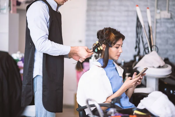 美容院的理发师用吹风机吹女顾客的头发 — 图库照片