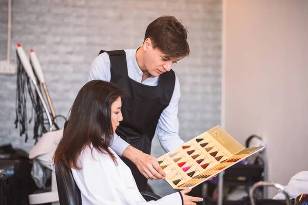 理发师建议漂亮的女性顾客从理发店的托盘中选择新的发色 — 图库照片