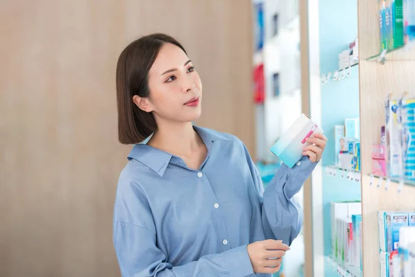 亚洲妇女药店的顾客选择和阅读药店货架上的维生素和药品标签 保健补充剂和药品概念 — 图库照片