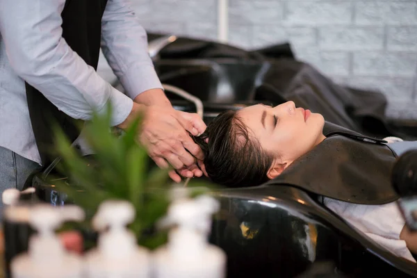 美发师洗头和按摩给美发厅的顾客 女人在美发厅休息 — 图库照片