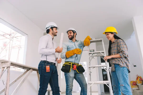 Group of diverse people construction worker wearing hardhat and safety equipment working together at construction site. Real estate industry.