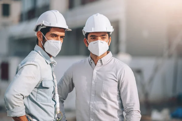 建設現場で働く2人の白人男性保護マスクを洗う エンジニアや建築家は Covidの不動産工事現場プロジェクトで一緒に働く19パンデミックの状況 — ストック写真