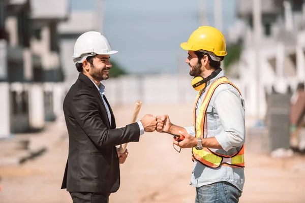 Happy workers at construction site, young civil engineer manager and architects handshaking at construction site and looking to next construction phase  , cooperation teamwork concept.