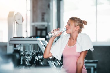 Spor salonunda egzersiz yaptıktan sonra su içen güzel beyaz kadın - Yaşam Tarzı ve Sağlık Konsepti