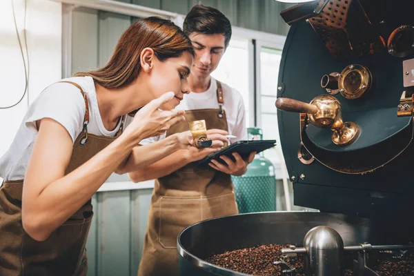 Genç Yetişkin İşletme Sahibinin Kafkasyalı Çifti Kahve Kızartma Fabrikasında Birlikte Uyanıyorlar, Profesyonel Barista Kaliteyi ve Aromayı Kontrol Ediyor.