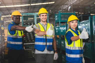 Çeşitli Depo çalışanlarından oluşan bir grup Başparmaklarıyla Fabrikada Başarı, Endüstriyel Yönetim ve Optimal Verimlilik İçin Takım Çalışması Yapıyor.