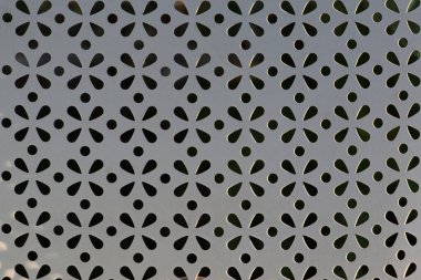 Arkasında çiçek deseni olan beyaz bir sandalyeye yakın plan..