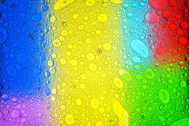 Birçok kırılgan sabun köpüğü ıslak yüzeyi kaplıyor Geometrik süsleme ile çok renkli arka plana karşı