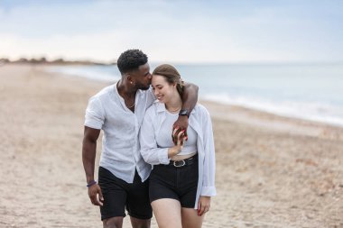 In the beautiful setting of Zapillo beach, a couple strolls hand in hand, basking in the warmth of the evening. Their smiles and gentle closeness highlight a moment of affection against the backdrop of gentle waves and soft sands. clipart