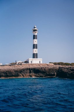 İspanya 'nın Menorca adasındaki güzel mavi deniz feneri. Deniz feneri çok uzaklardan yol gösteriyor.