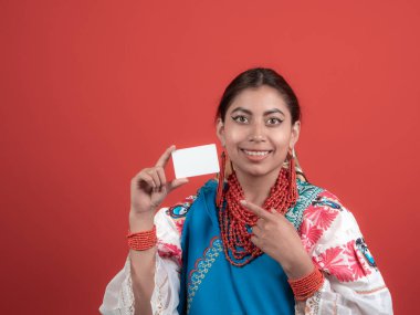 ecuadorian latina girl holding a credit card and pointing with the other one, on red background clipart