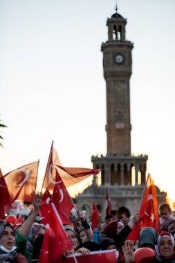 İzmir, Türkiye - 15 Temmuz 2022: 15 Temmuz İzmir Demokrasi Günü. İzmir 'deki Konak Meydanı' nda ve tarihi saat kulesinin önünde Türk bayrakları taşıyan çan kulesi.