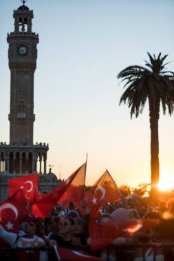 İzmir, Türkiye - 15 Temmuz 2022: 15 Temmuz İzmir Demokrasi Günü. İzmir 'deki Konak Meydanı' nda ve tarihi saat kulesinin önünde Türk bayrakları taşıyan çan kulesi.