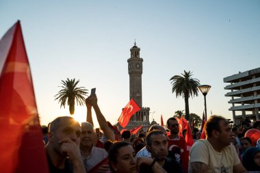 İzmir, Türkiye - 15 Temmuz 2022: 15 Temmuz İzmir Demokrasi Günü. İzmir 'deki Konak Meydanı' nda ve tarihi saat kulesinin önünde Türk bayrakları taşıyan çan kulesi.