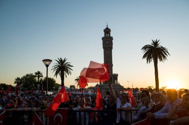 İzmir, Türkiye - 15 Temmuz 2022: 15 Temmuz İzmir Demokrasi Günü. İzmir 'deki Konak Meydanı' nda ve tarihi saat kulesinin önünde Türk bayrakları taşıyan çan kulesi.