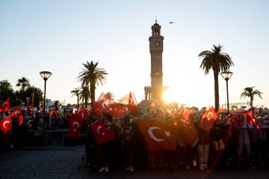 İzmir, Türkiye - 15 Temmuz 2022: 15 Temmuz İzmir Demokrasi Günü. İzmir 'deki Konak Meydanı' nda ve tarihi saat kulesinin önünde Türk bayrakları taşıyan çan kulesi.