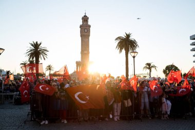 İzmir, Türkiye - 15 Temmuz 2022: 15 Temmuz İzmir Demokrasi Günü. İzmir 'deki Konak Meydanı' nda ve tarihi saat kulesinin önünde Türk bayrakları taşıyan çan kulesi.