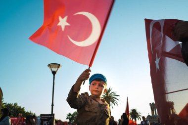 İzmir, Türkiye - 15 Temmuz 2022: 15 Temmuz Demokrasi ve Konak Meydanı İzmir Özgürlük Günü kutlamalarında Türk bayrağı ve asker kostümü giymiş bir çocuk.