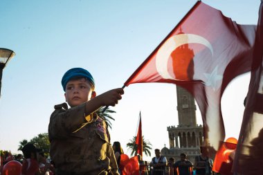 İzmir, Türkiye - 15 Temmuz 2022: 15 Temmuz Demokrasi ve Konak Meydanı İzmir Özgürlük Günü kutlamalarında Türk bayrağı ve asker kostümü giymiş bir çocuk.