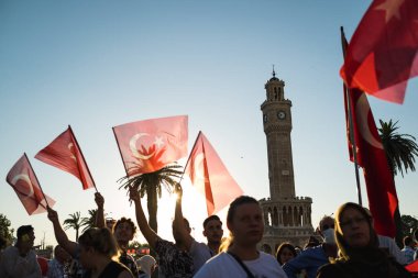 İzmir, Türkiye - 15 Temmuz 2022: 15 Temmuz İzmir Demokrasi Günü. İzmir 'deki Konak Meydanı' nda ve tarihi saat kulesinin önünde Türk bayrakları taşıyan çan kulesi.