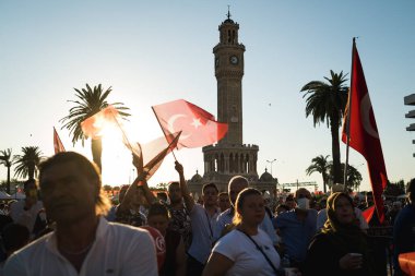 İzmir, Türkiye - 15 Temmuz 2022: 15 Temmuz İzmir Demokrasi Günü. İzmir 'deki Konak Meydanı' nda ve tarihi saat kulesinin önünde Türk bayrakları taşıyan çan kulesi.