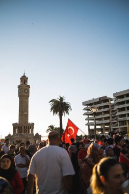 İzmir, Türkiye - 15 Temmuz 2022: 15 Temmuz İzmir Demokrasi Günü. İzmir 'deki Konak Meydanı' nda ve tarihi saat kulesinin önünde Türk bayrakları taşıyan çan kulesi.