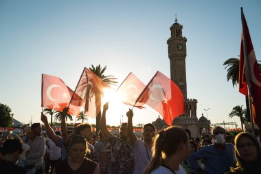 İzmir, Türkiye - 15 Temmuz 2022: 15 Temmuz İzmir Demokrasi Günü. İzmir 'deki Konak Meydanı' nda ve tarihi saat kulesinin önünde Türk bayrakları taşıyan çan kulesi.