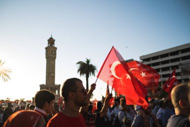 İzmir, Türkiye - 15 Temmuz 2022: 15 Temmuz İzmir Demokrasi Günü. İzmir 'deki Konak Meydanı' nda ve tarihi saat kulesinin önünde Türk bayrakları taşıyan çan kulesi.