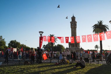 İzmir, Türkiye - 15 Temmuz 2022: 15 Temmuz İzmir Demokrasi Günü. İzmir 'deki Konak Meydanı' nda ve tarihi saat kulesinin önünde Türk bayrakları taşıyan çan kulesi.