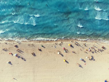 İzmir, Türkiye - 17 Ağustos 2022: Yaz mevsiminde Ilica plajının havadan görünüşü Cesme İzmir Türkiye plajında şemsiyeli insanlar var