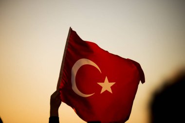 İzmir 'in kurtuluş gününde gün batımında bir Türk bayrağının yakın çekimi