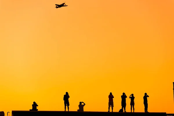 Silhuett Några Fotografer Som Fotograferar Ett Akrobatiskt Plan Vid Solnedgången — Stockfoto